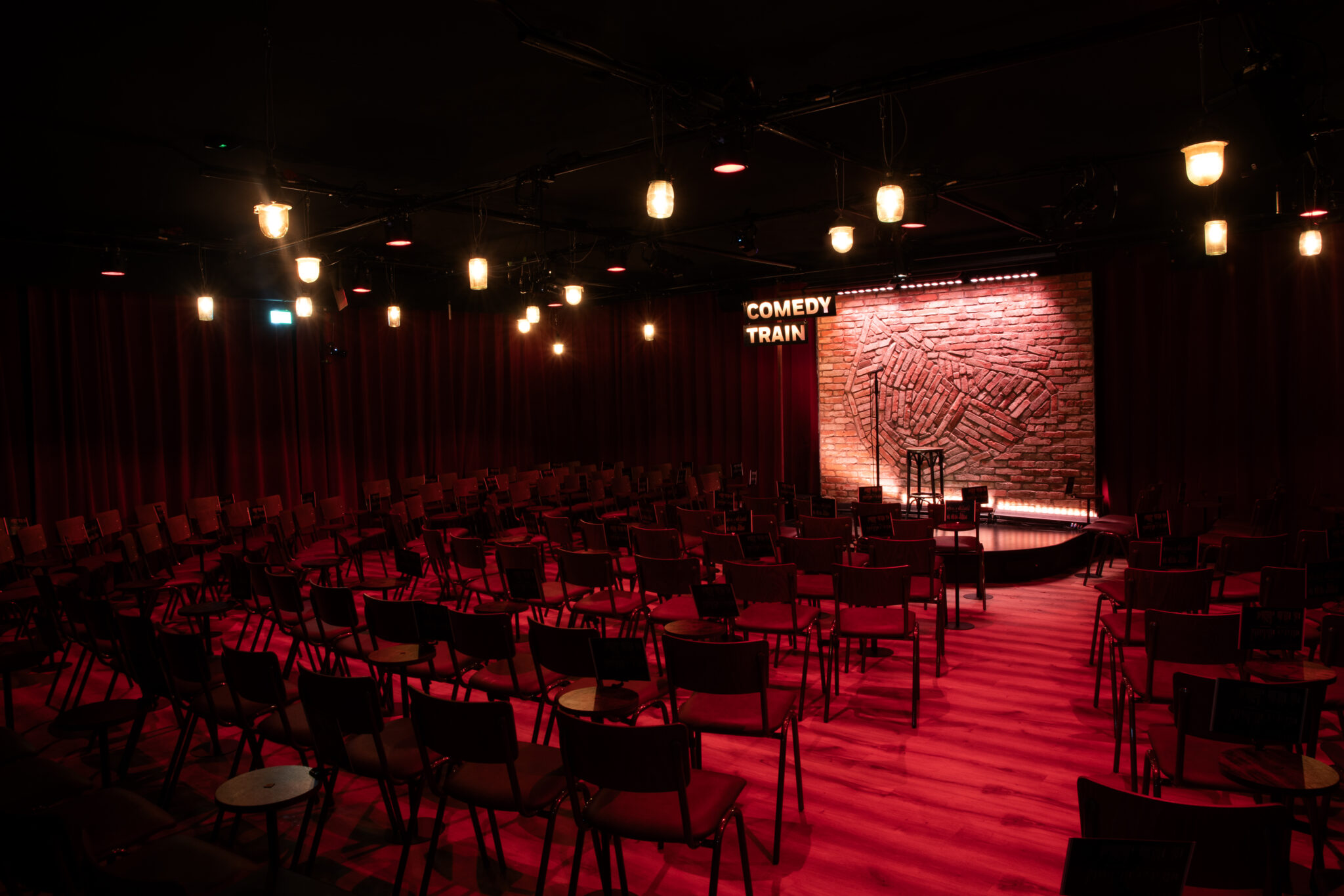 Het podium en de rode verlichting van de Comedytrain-club op de Westergas